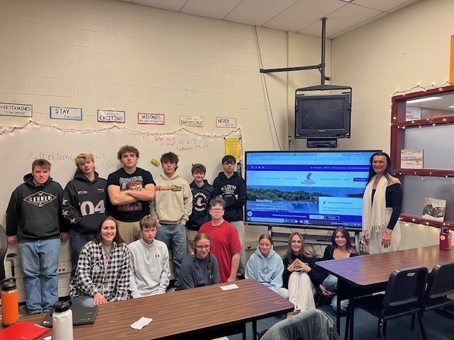 students and woman pose for group photo