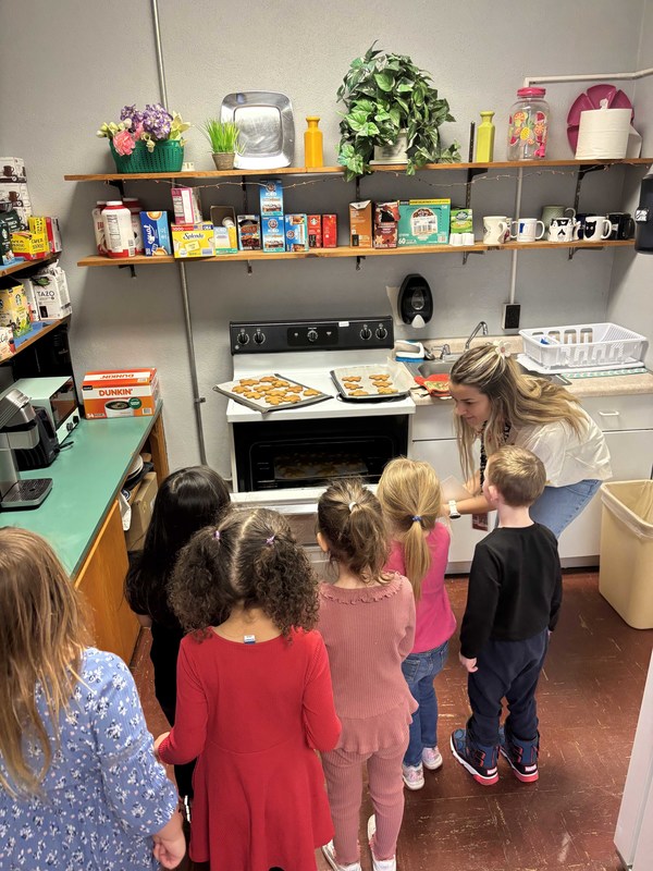 students and teacher making cookies