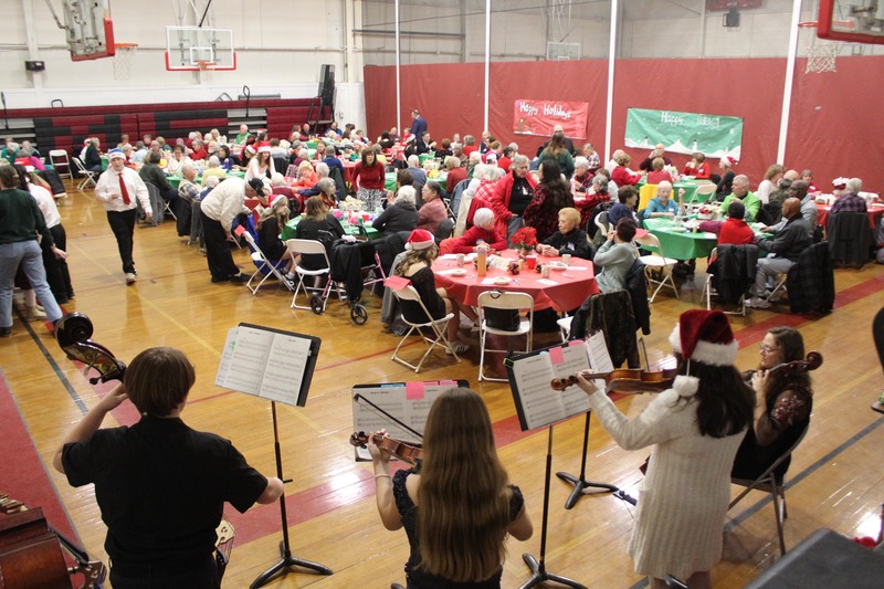 students playing instruments to diners in gym