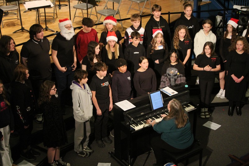 student chorus singing on risers in auditorium