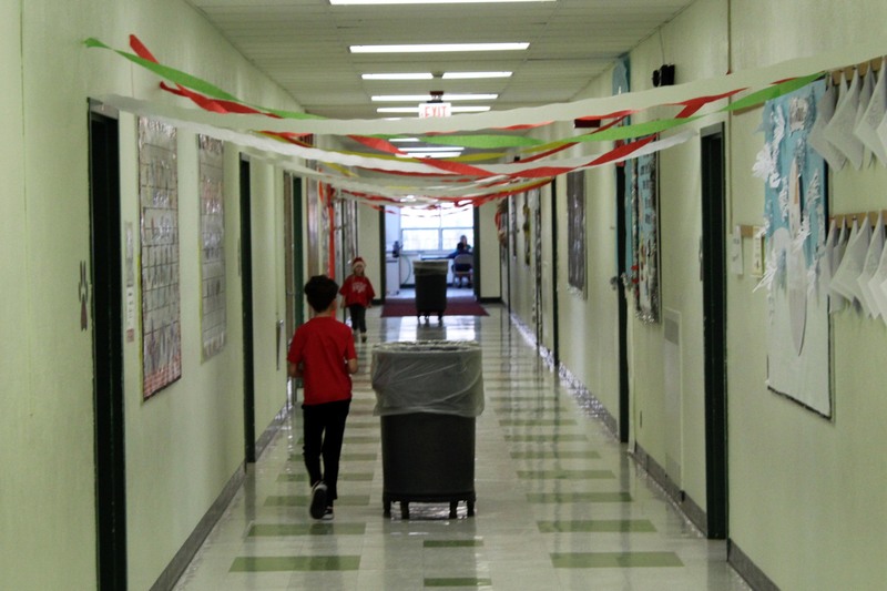students walking in hallway strewn with holiday ribbons