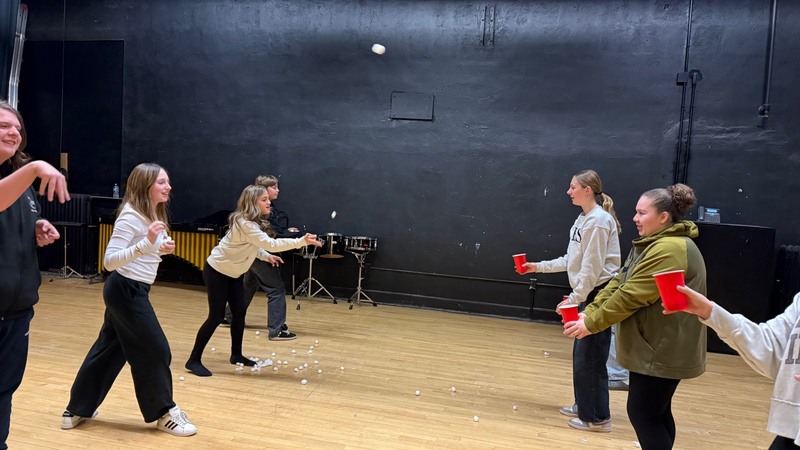 students tossing white balls