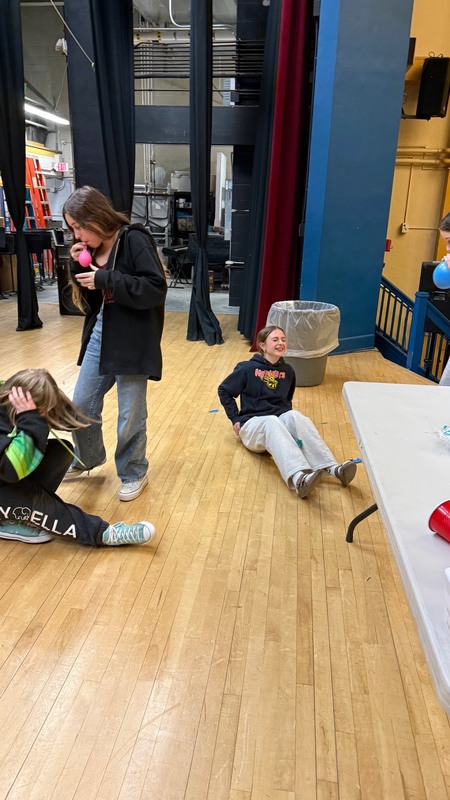 students popping balloons