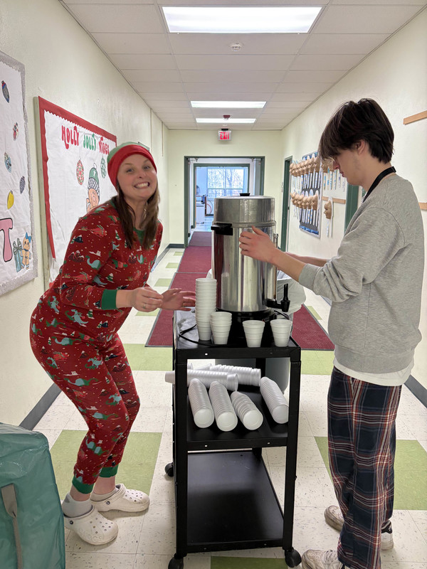 woman and young man with cocoa cart in hallway