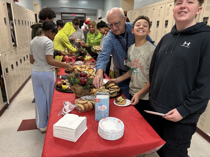 students and teachers eating breakfast buffet in hallway
