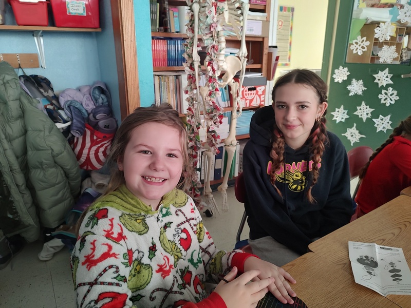 two girls smiling while sitting at table