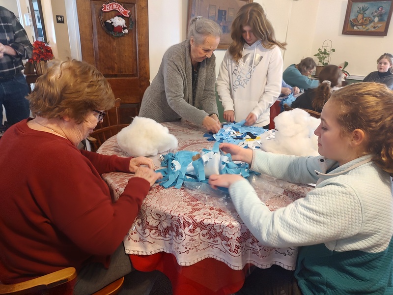 students and seniors making pillows at table 