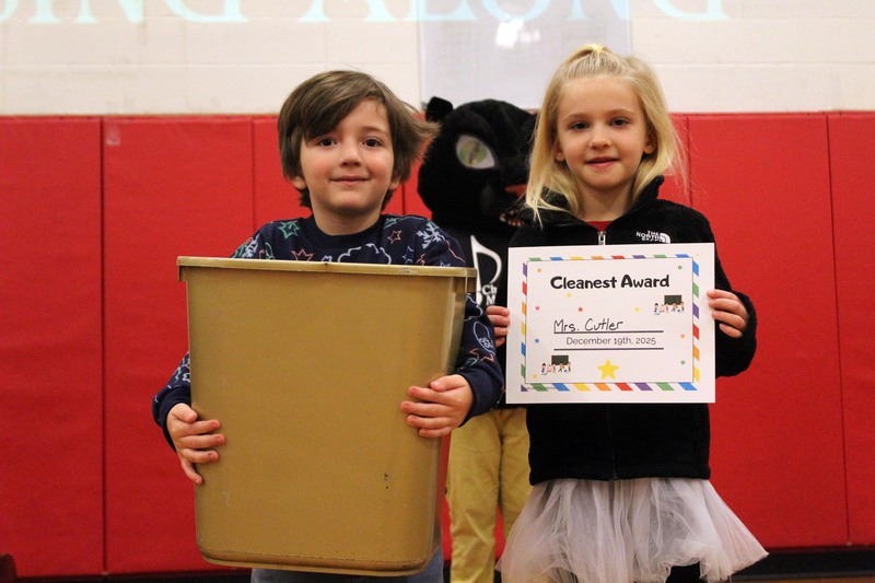 boy holding golden trashcan and girl holding certificate
