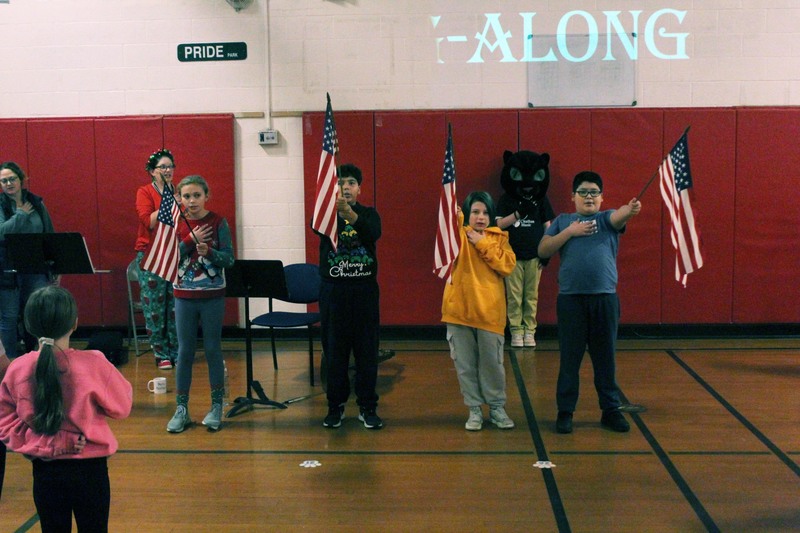 students holding up small American flags