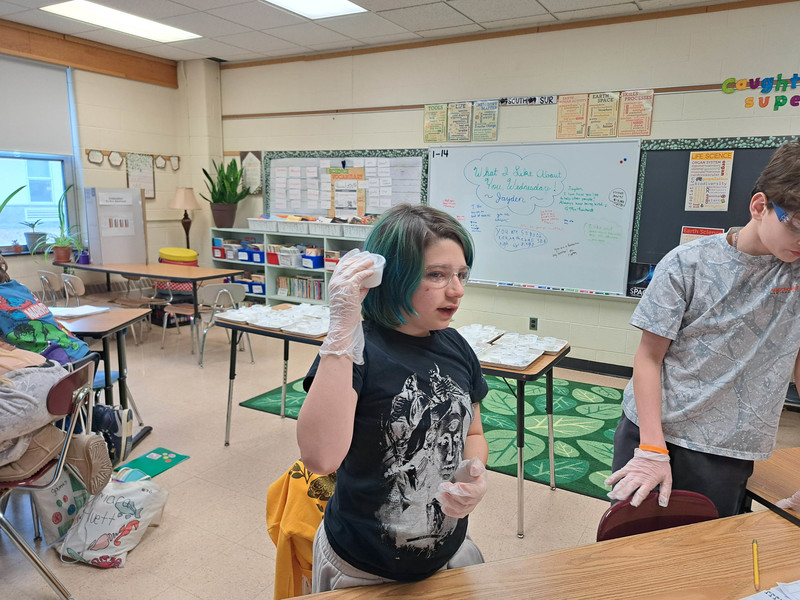 student listening to substance in cup