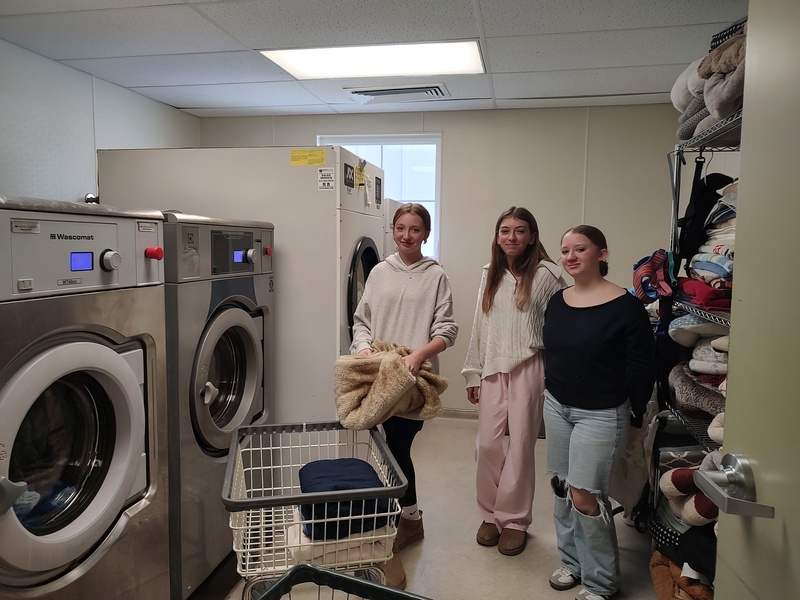 three girls folding laundry