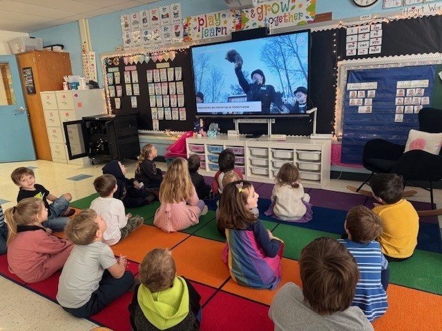 class watching Punxsutawney Phil on TV