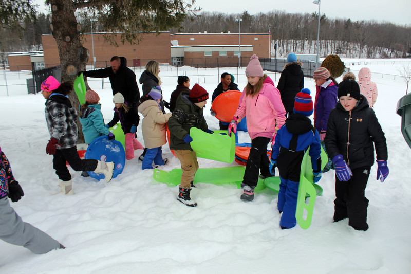 students picking up sleds 