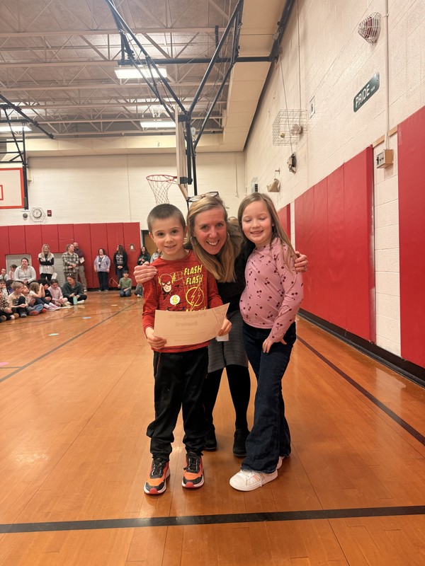 Mrs. reno poses with boy and girl from winning class