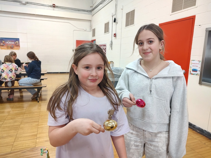 two girls holding eggs in spoons