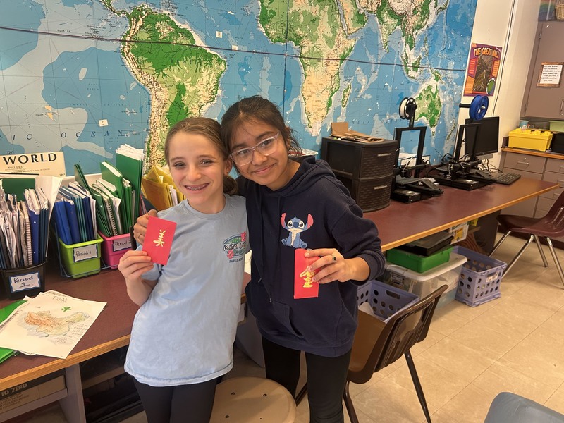 two girls holding red envelopes