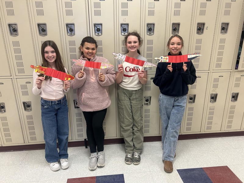four girls holding paper dragons