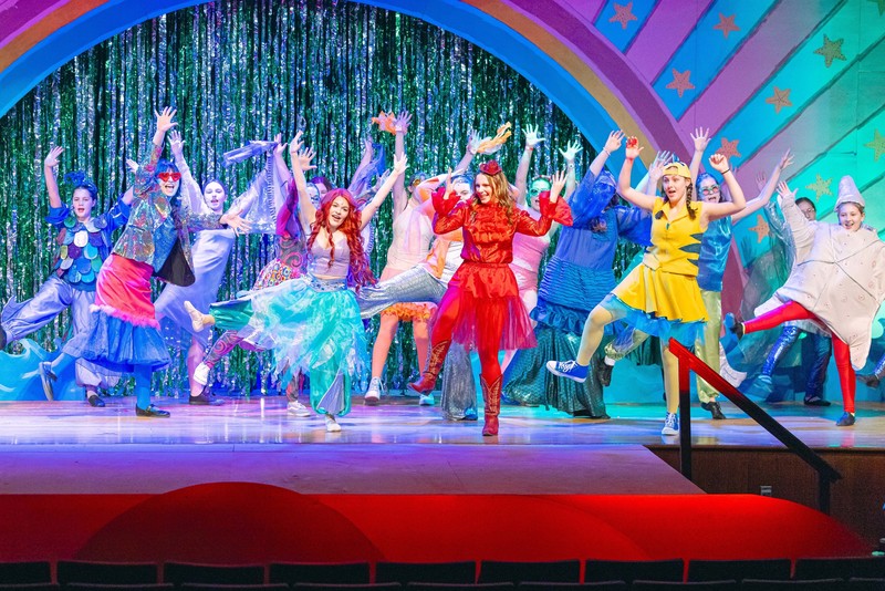 students in costume dancing on stage