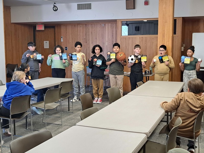 students standing ion line holding up cards