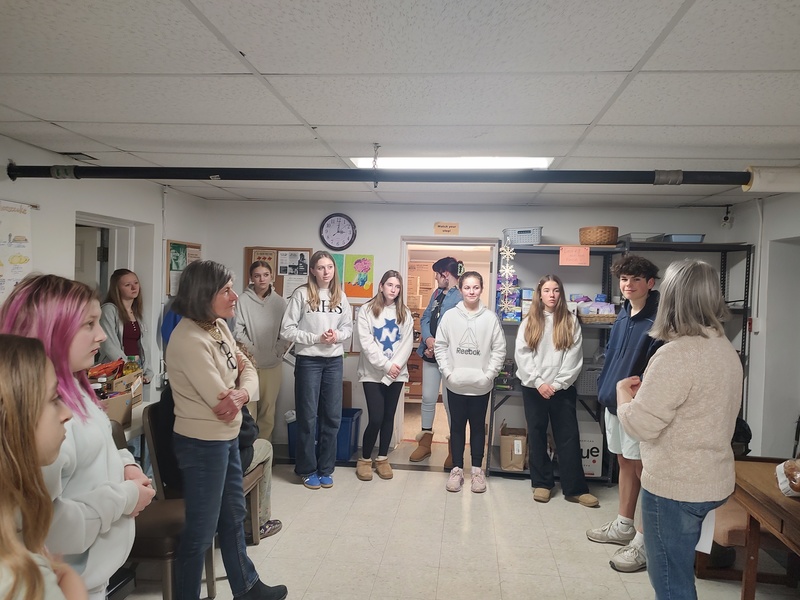 woman showing students around the food pantry