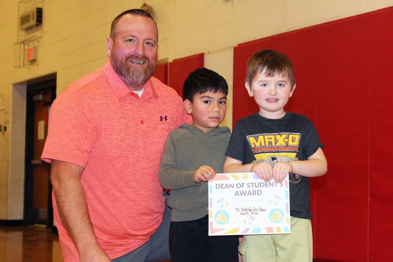 man posing with two boys holding Dean of Students' Award certificate
