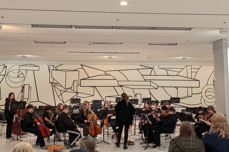grade 7/8 orchestra performing in the South Concourse
