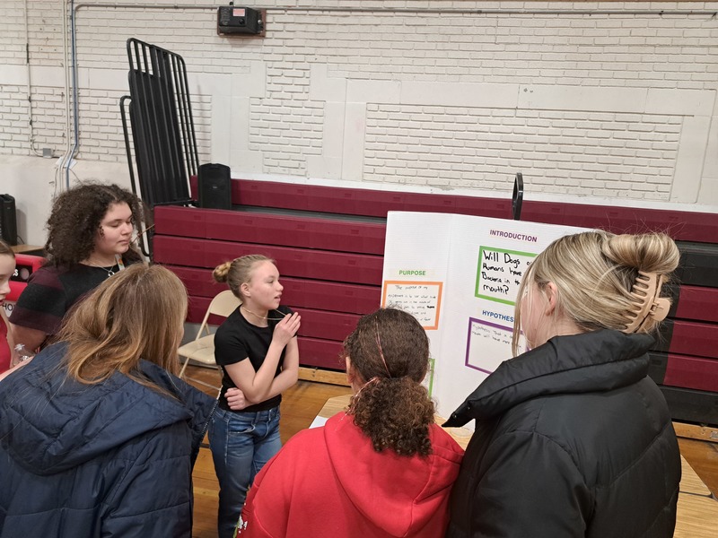 girl showing audience her science fair display