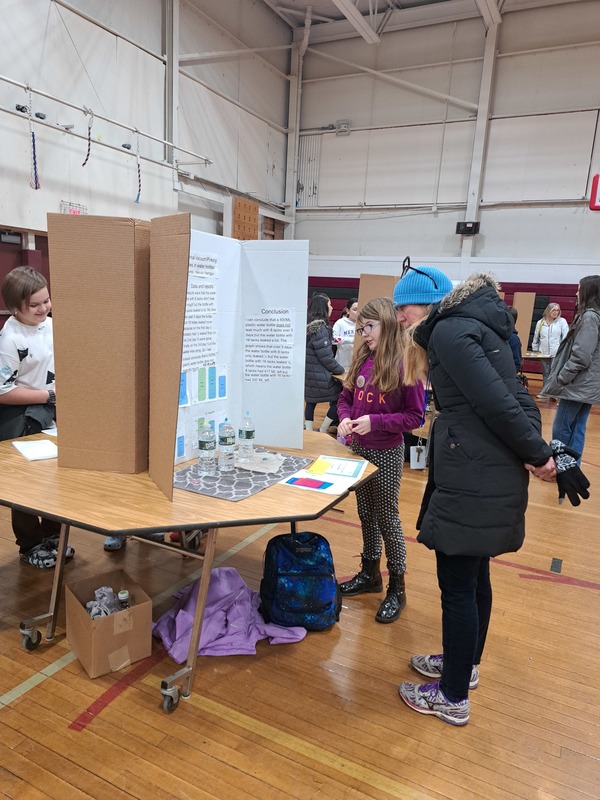 woman and girl looking at science fair display