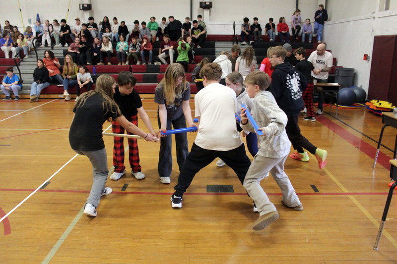 student moving ball by holding up tracks to roll the ball through