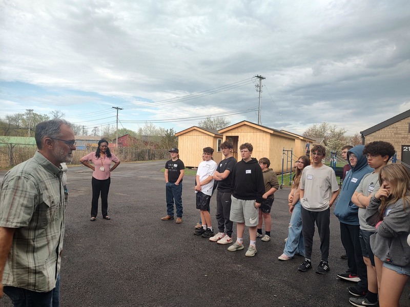 sman talking to group of students outside Questar III facility