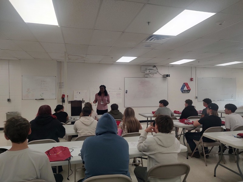woman talking to group of students in classroom