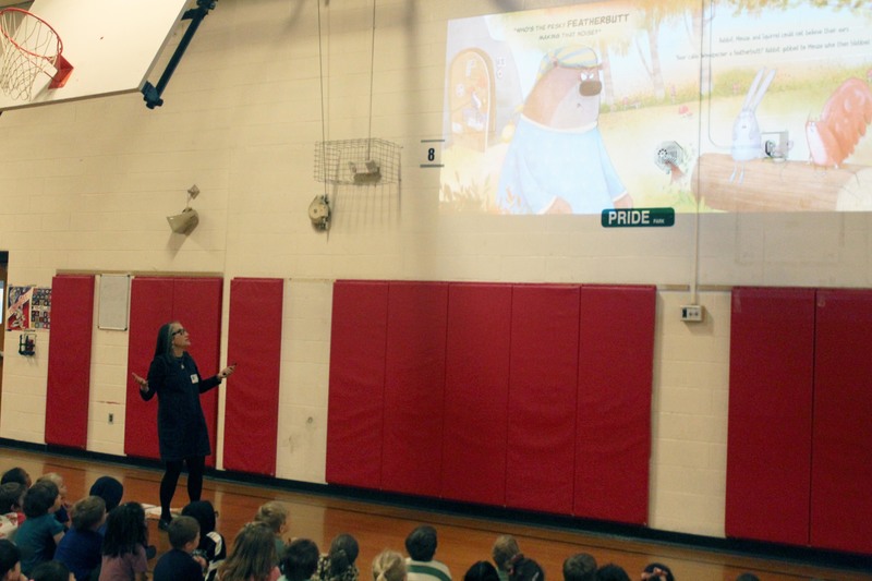 woman readiinbg from story projected on gym wall