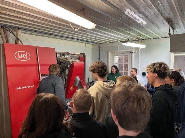 students looking at milking machinery
