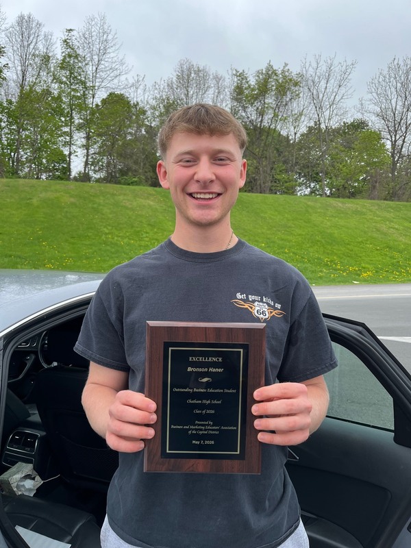 young man holding award plaque