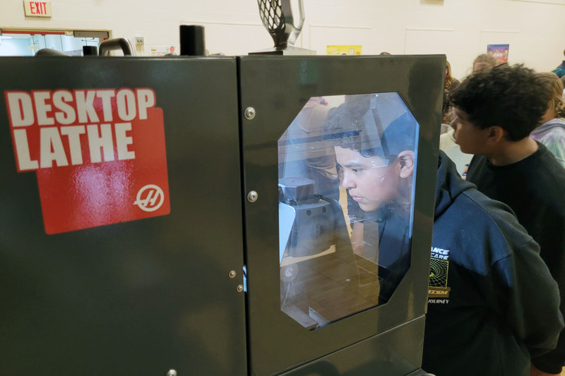 boy looking into automated lathes