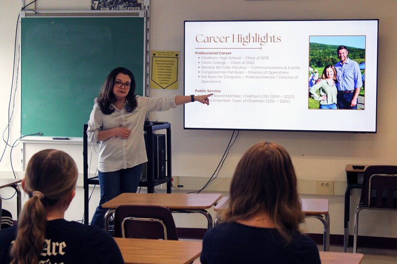 woman talking to seated students