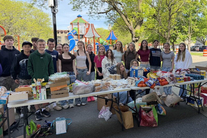 students pose with table filled will food and other goods