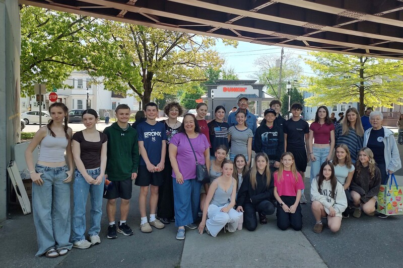 students pose for group photo under bridge