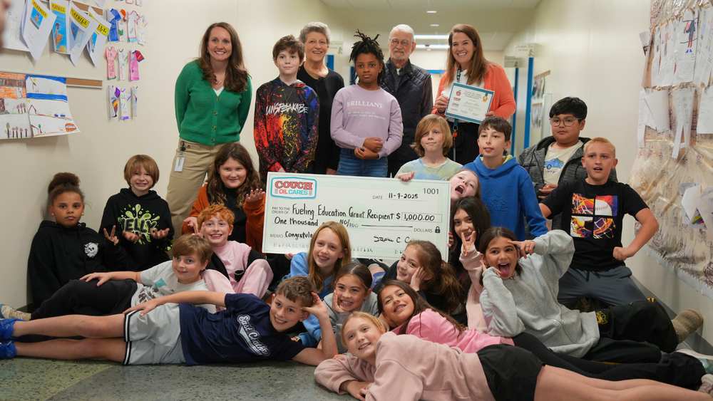 Representatives from Couch Oil visit Dr. Jessica Allen and students from her fifth grade class at CGE to present a grant check.
