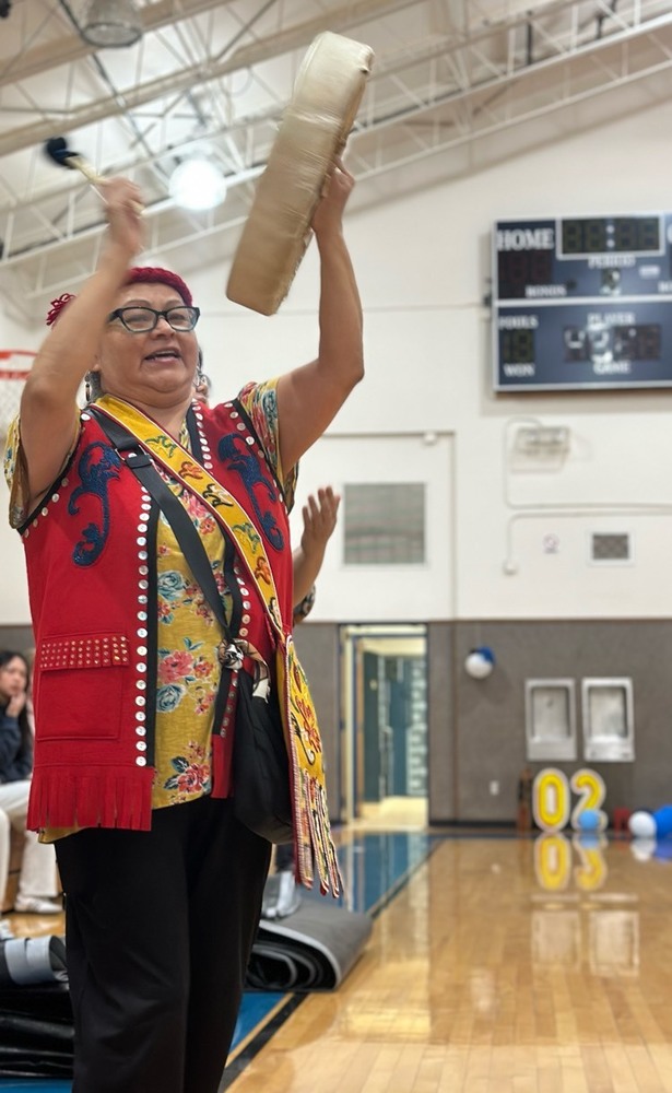 Ms. Pauline Johnson plays her drum during the singing and dancing presentation at the high school gym.