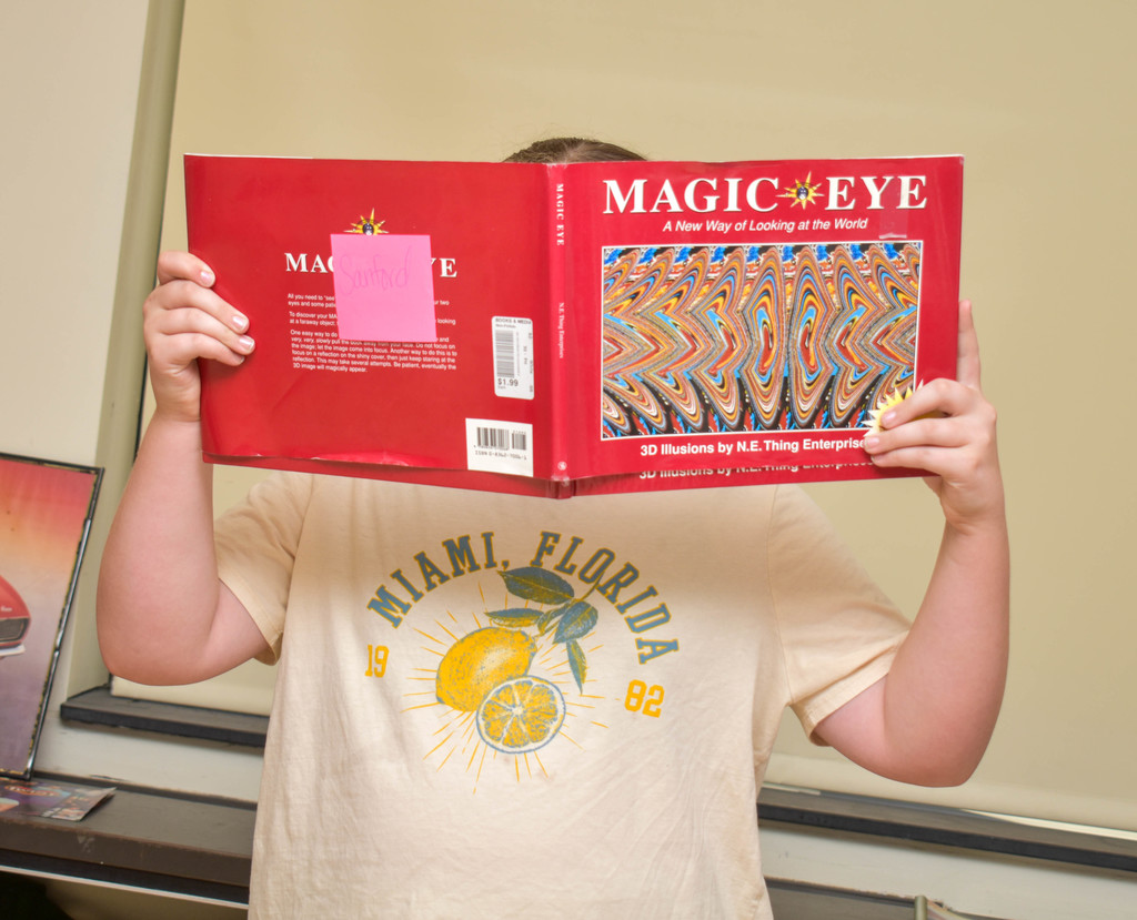 student looking at magic eye book