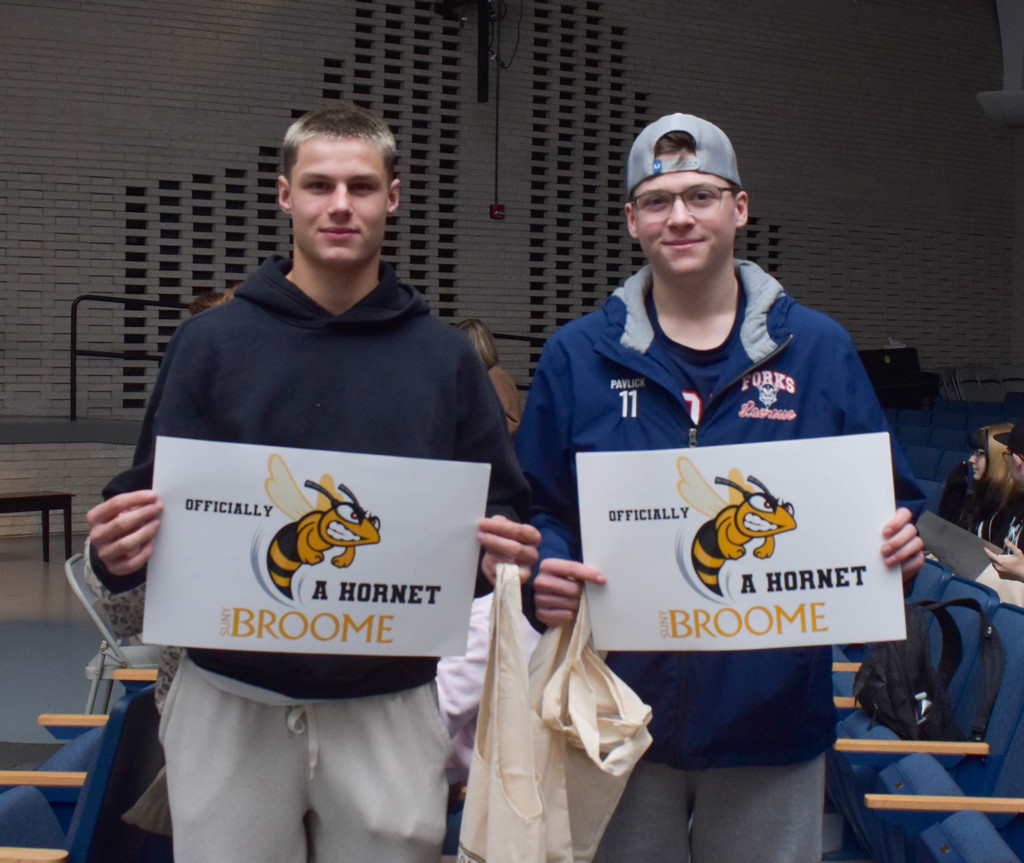 students holding SUNY Broome posters