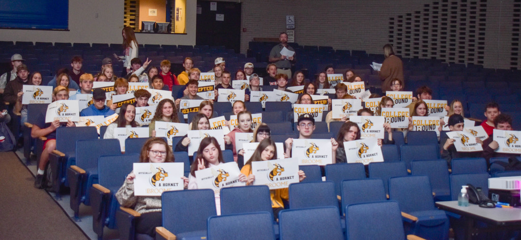students holding suny broome posters