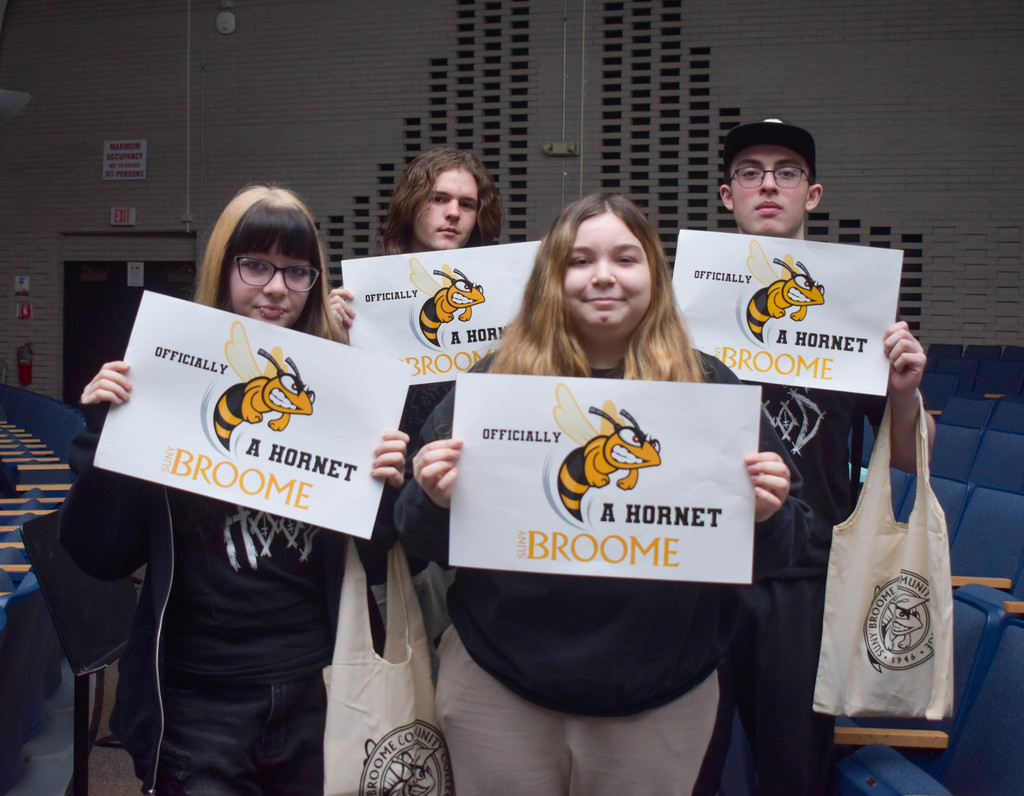 students holding suny broome posters