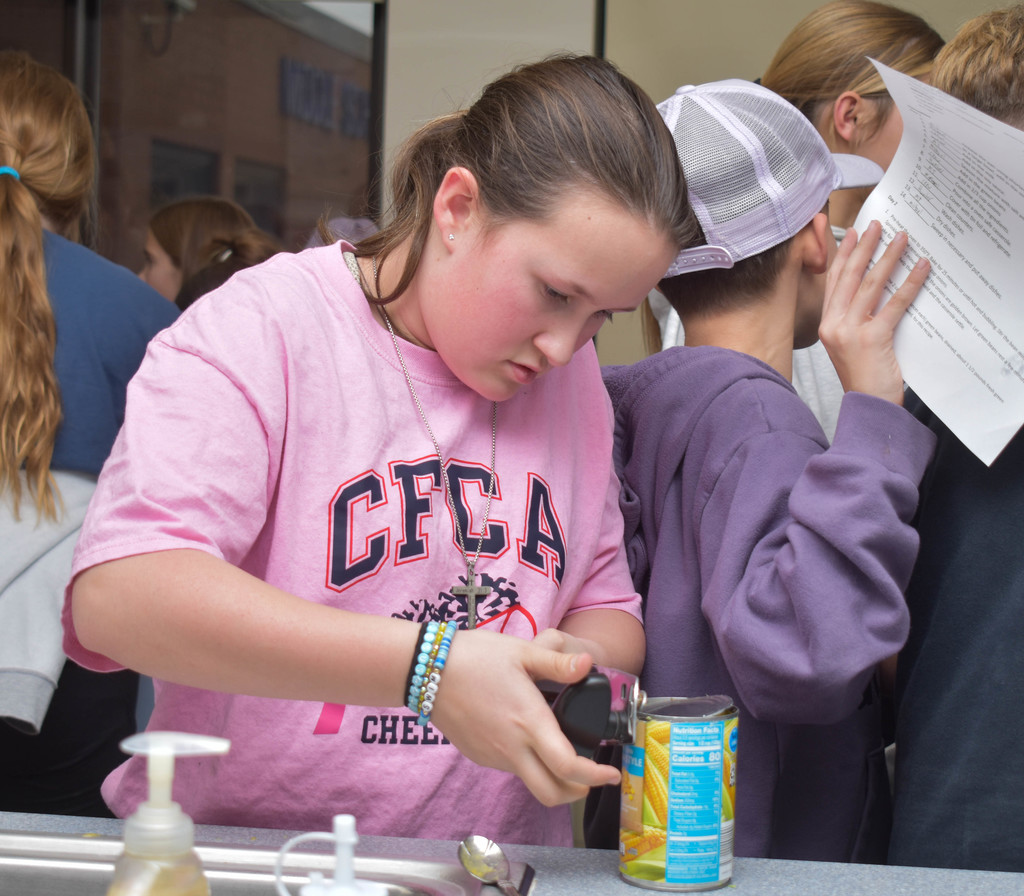 student opening can of corn