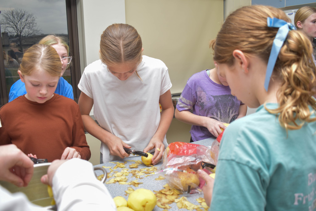 students peeling potatoes