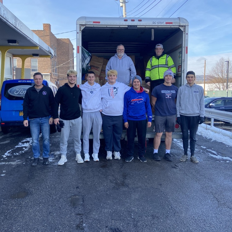 football players standing in front of school bus