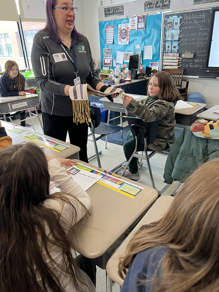 guest speaker with student and wampum belt
