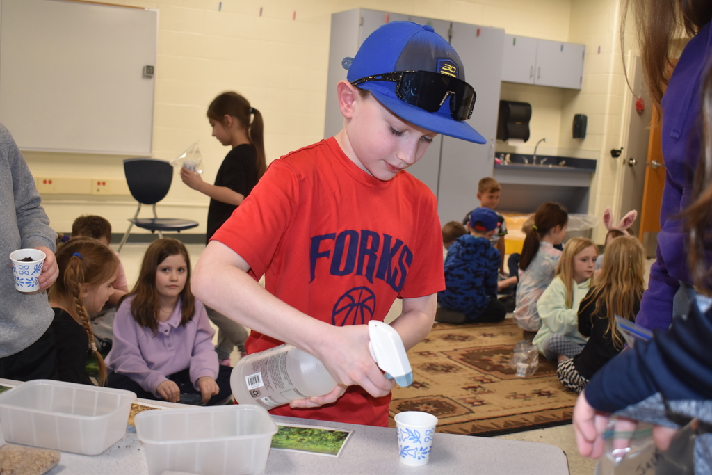 student watering seeds