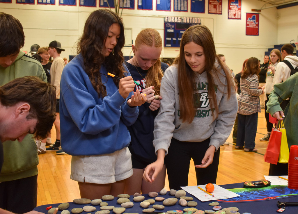 students in gym talking with community organization set up at table